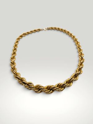 un collier en or représentant une corde torsadée sur fond blanc
