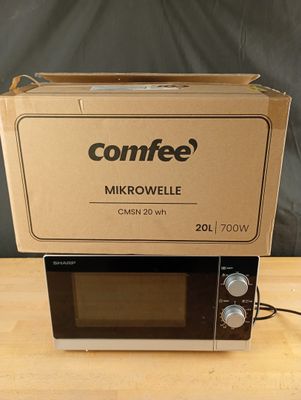 un micro-ondes posé sur une boîte, sur une table