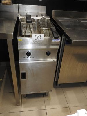 une cuisinière en acier inoxydable sur laquelle sont posées deux casseroles, dans une cuisine