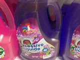 purple and pink liquid bottles are on a shelf in a store