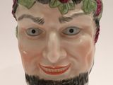 a ceramic cup with a man ' s face painted on it