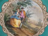 a plate with a painting of a man and a woman on it