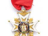 un gros plan d'une médaille sur fond blanc, accompagnée d'un ruban rouge