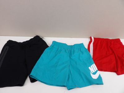 three pairs of nike shorts on a white table