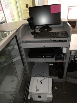 a computer desk with a printer and a monitor on it