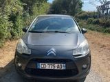 a black car parked on the side of a dirt road