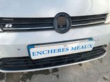 the front end of a white car with a license plate on it