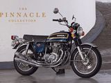 a motorcycle that is parked in front of the pinnacle collection sign