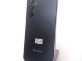 the back of a black samsung phone sitting on top of a stand