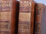 two old books are stacked on top of each other on a shelf