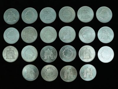 some silver coins are arranged in a row on a black surface