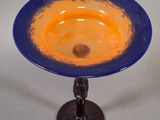 a blue and orange glass bowl on a stand