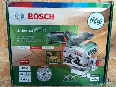 La boîte d'une scie circulaire universelle Bosch est ouverte sur la table.