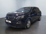 La voiture noire est garée dans une grande pièce au sol noir.