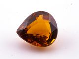 a close up of a faceted brown diamond on a white surface