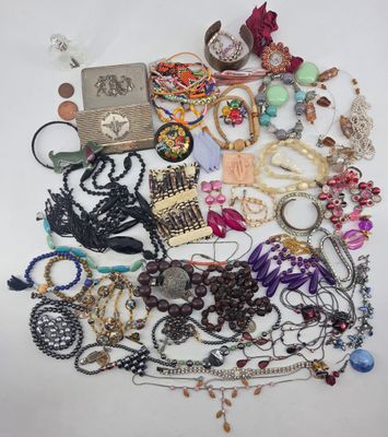 a pile of assorted necklaces and bracelets on a white surface