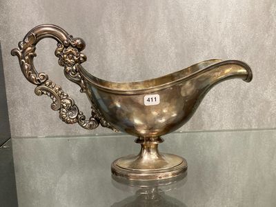 une saucière en argent posée sur une table en verre