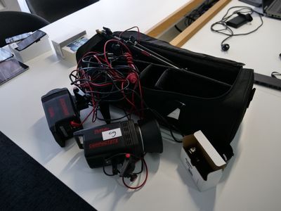 un ordinateur portable posé sur un bureau, avec tout un tas de câbles autour
