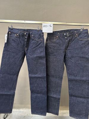 deux paires de jeans suspendues à un portant dans un magasin