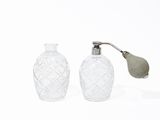 two glass bottles with a metal handle and a leaf on top of them