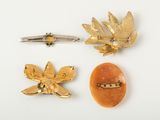 three gold brooches and a broochet on a white surface
