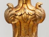 un vase en or orné d'un oiseau, posé sur une table