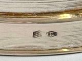 a close up of a silver plate with a clock on it