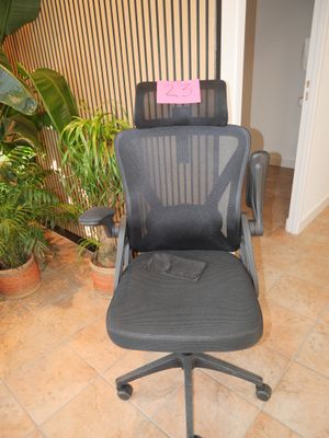 a black office chair with a pink sticker on it