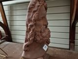 a statue of a man with long hair and a beard on a table