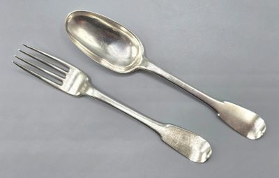 deux cuillères et une fourchette en argent sur une table
