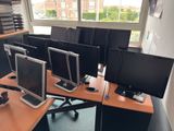 many computer screens on the desk in this office