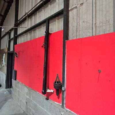 a red wall that has a bunch of hooks on it