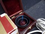 a wooden box with a bowl inside of it on the ground