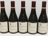six bouteilles de vin sont alignées sur une table