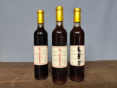 three bottles of wine sitting on a wooden table