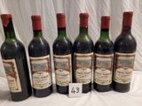 six bottles of wine are lined up in a row on a table