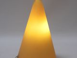 a yellow cone shaped lamp on a white surface