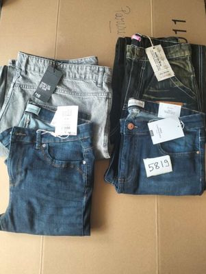 three pairs of jeans are sitting on a cardboard box with price tags
