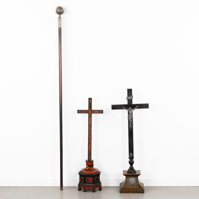 two crosses and a pole in a room with a white wall