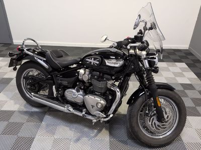 une moto noire garée sur un sol à damier