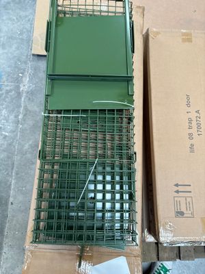 a green bird cage with a green bird inside of it