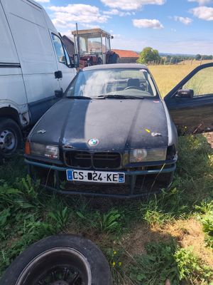 a car that is sitting in the grass next to a truck