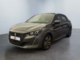 La voiture grise est garée dans une grande pièce au sol noir.