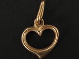un pendentif en forme de cœur doré sur fond noir
