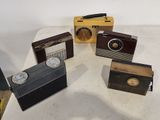 plusieurs radios à l'ancienne posées sur une table blanche