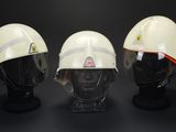 three white helmets are lined up against a black background