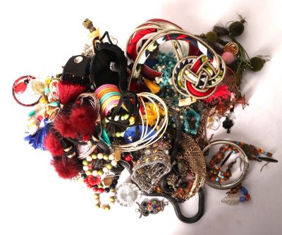 a pile of assorted jewelry on a white surface