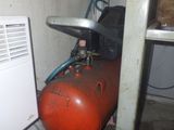 a red gas tank sitting next to an air conditioner