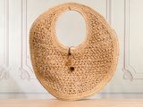 le grand sac en osier est posé sur une table devant un mur
