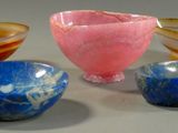 several different colored glass bowls and bowls sitting on a table